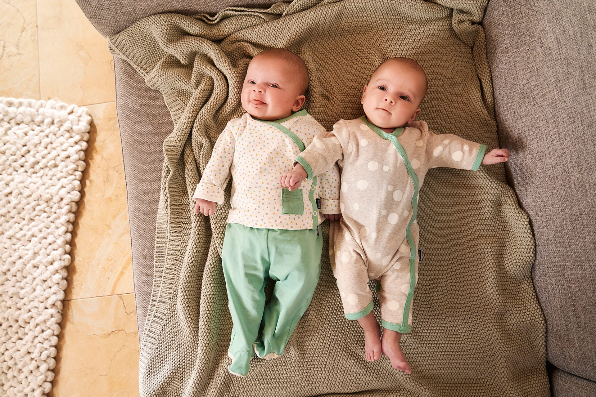 Emmi Pikler Erziehung | 2 Babys liegen zusammen auf einer Decke und schauen nach oben 