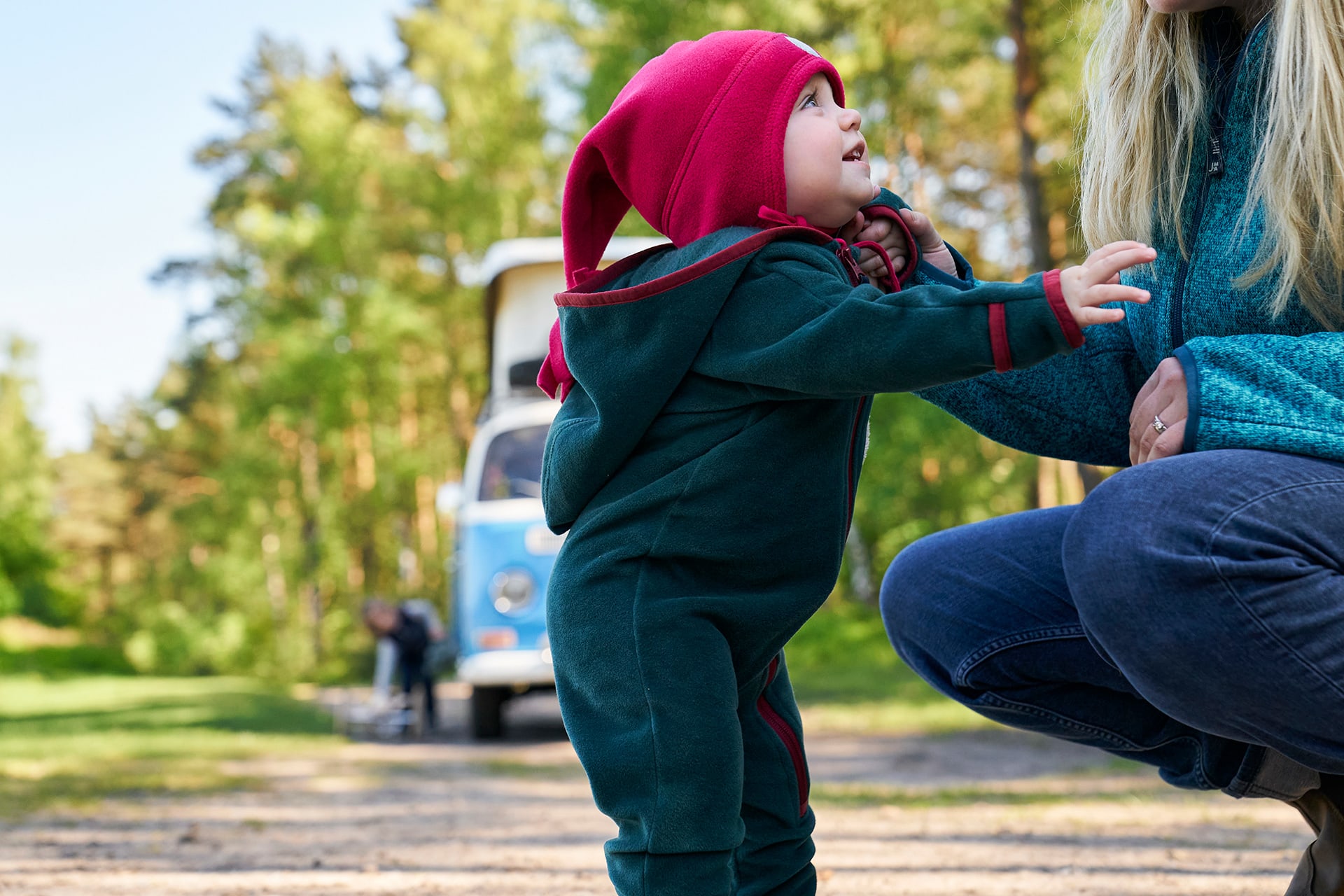 Emmi Pikler Erziehung | Kleinkind mit pinker Zipfelmütze hält sich an der Mama fest