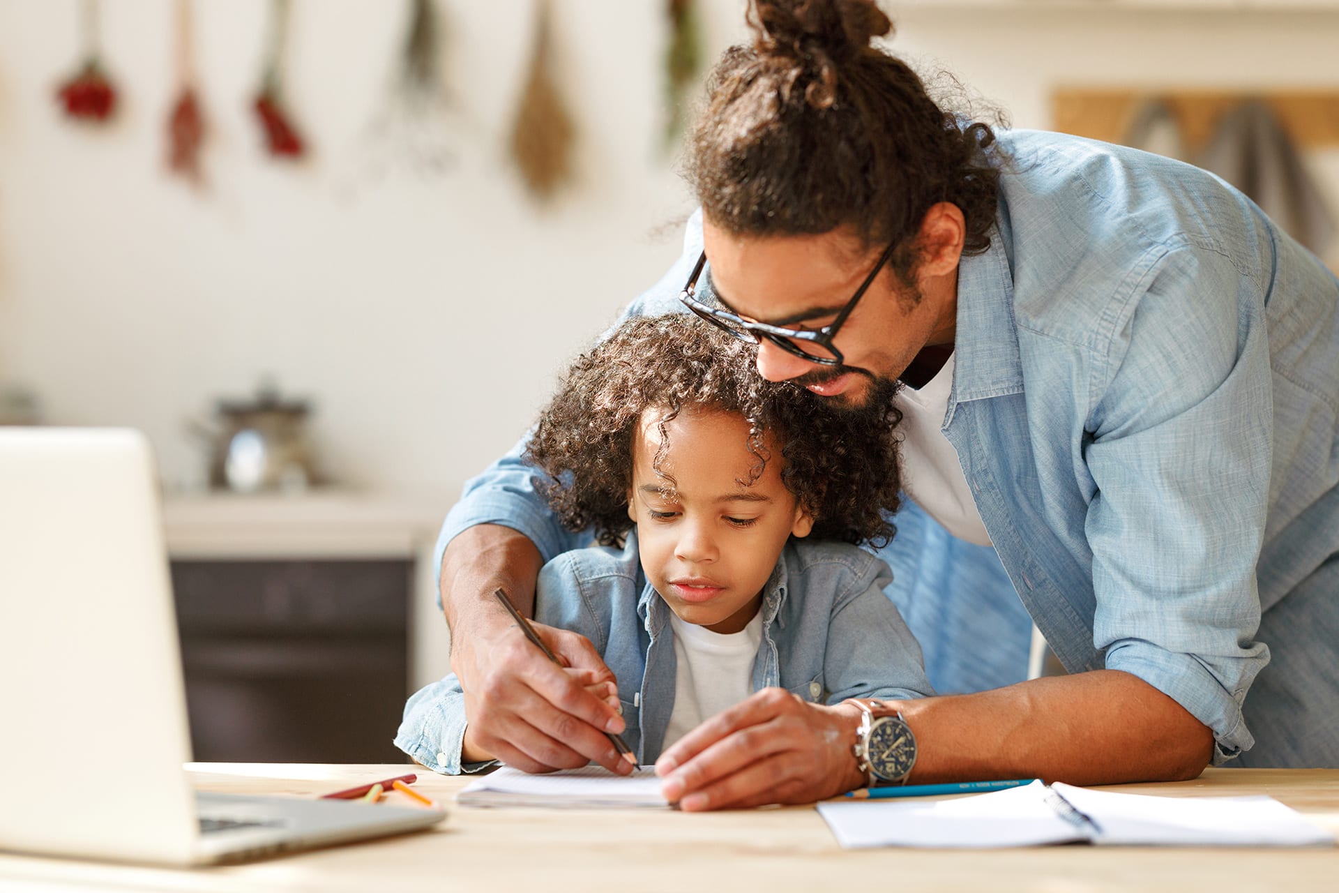 Hausaufgabenbetreuung | Vater hilft seinem Sohn bei den Hausaufgaben