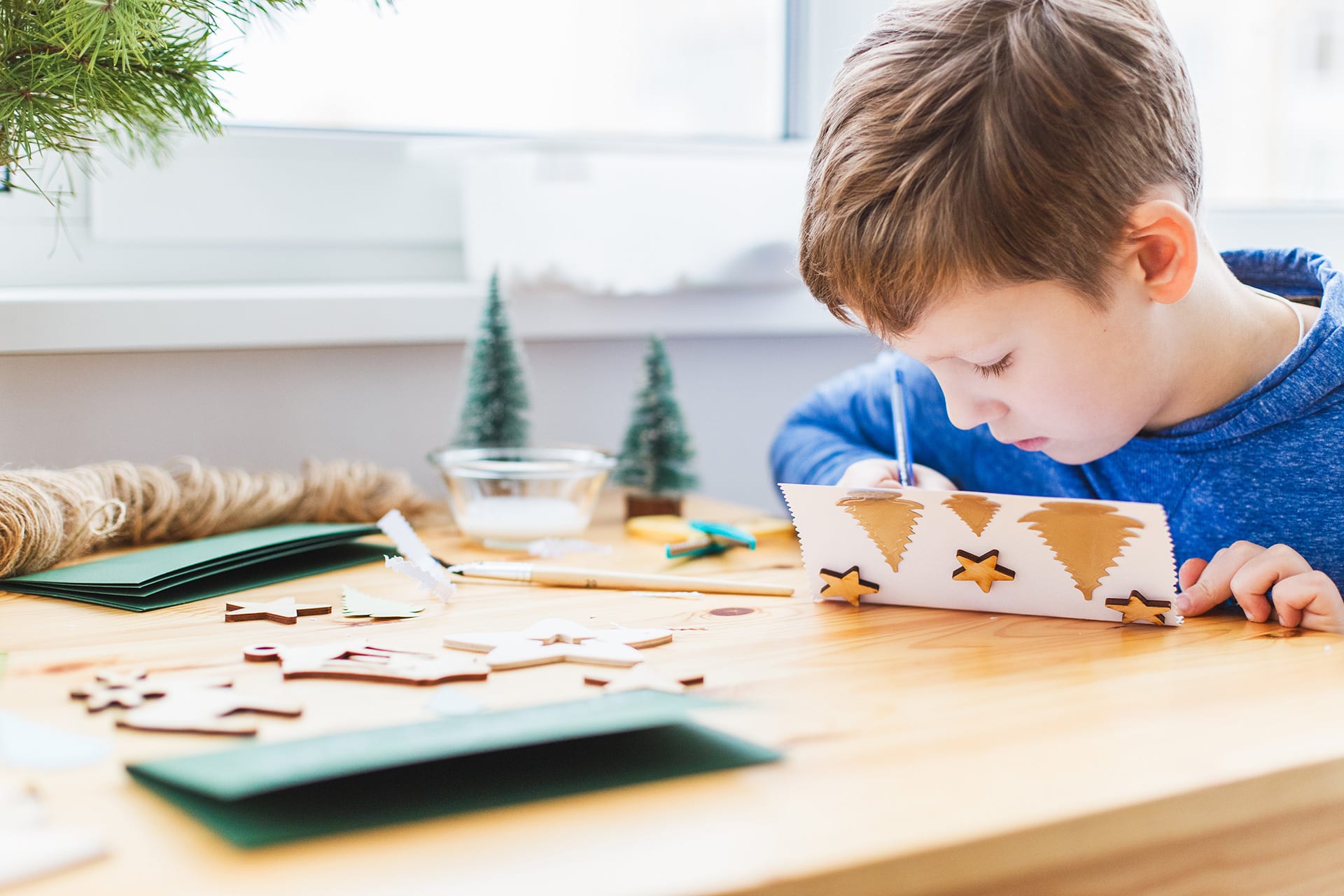Weihnachtsgeschenke basteln mit Kindern | Junge bastelt Karten
