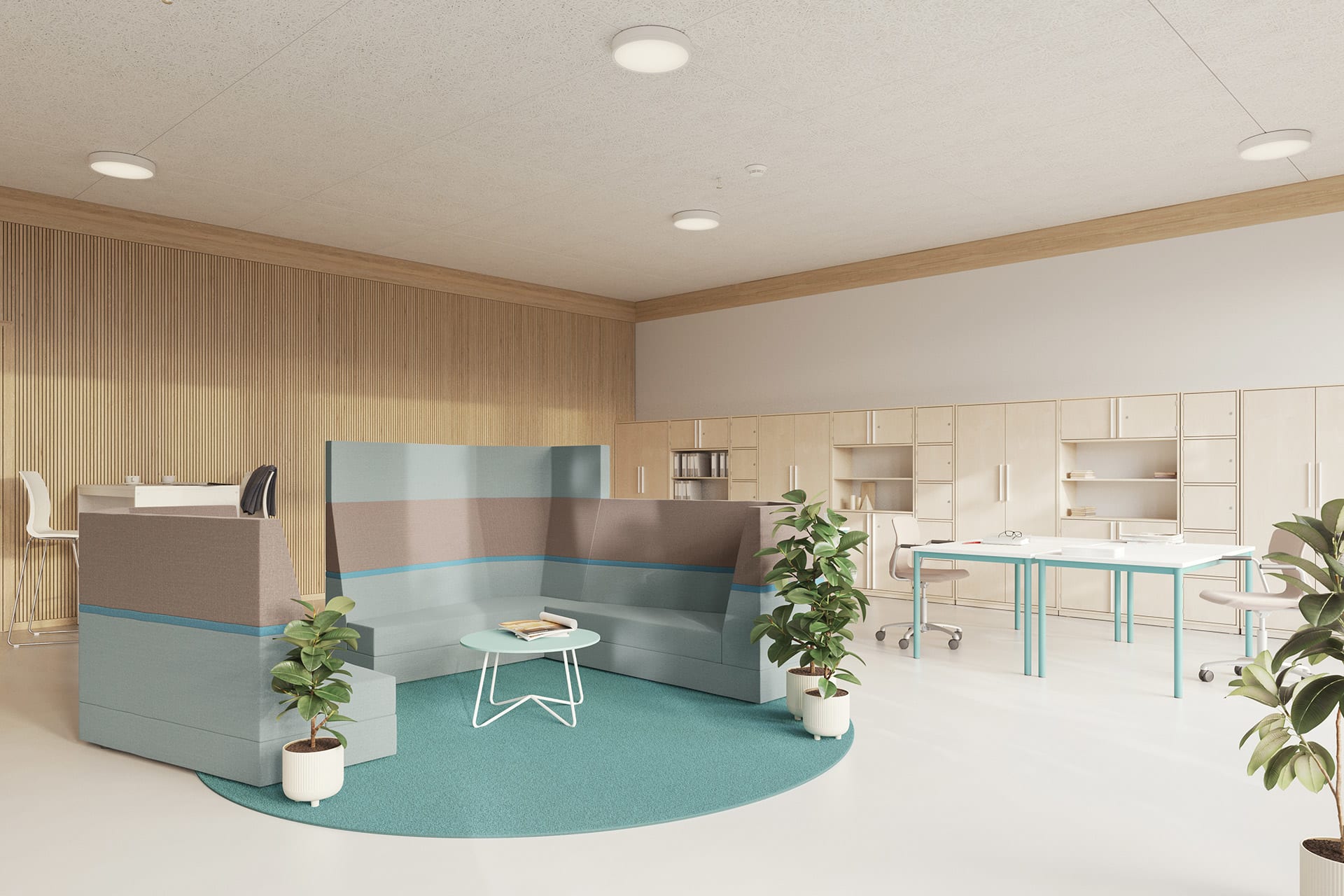 Farbgestaltung von Räumen | Raum mit drei Besprechungssofas in Grau und Blau stehen auf einem runden blauen Teppich, daneben ein Tisch mit zwei Bürostühlen und Wandregale