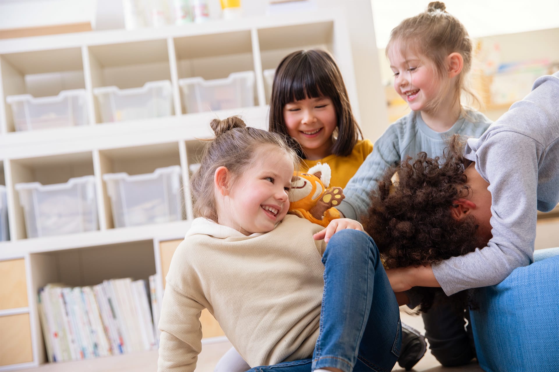 Emotionen | 2 | Image | Handpuppe Katzenbär | Kind mit grauen Langarmshirt und dunklen Haaren hat seinen Kopf nach unten Kinder spielen mit Katzenbär