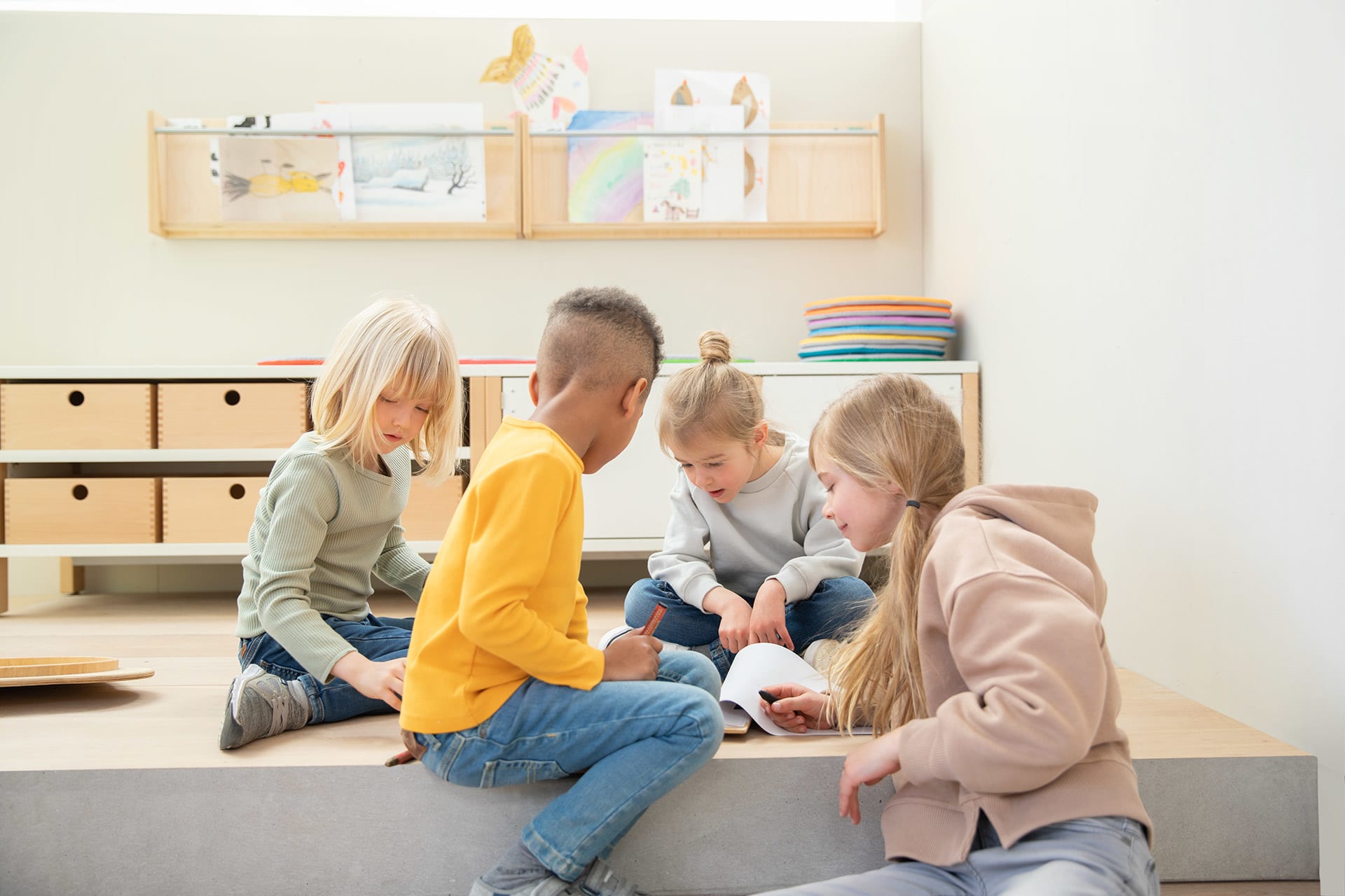 Future Skills | Image | Teamfähigkeit | Kinder spielen zusammen sitzen auf einem Podest