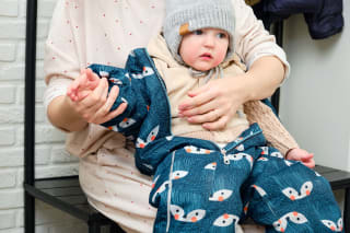 Baby im Frühling richtig anziehen | Mama mit Baby sitzen draußen