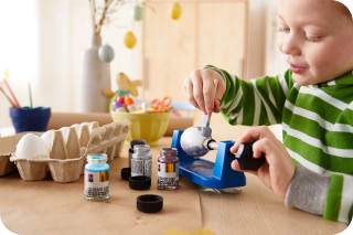 Osterdeko basteln mit Kindern | Junge malt mit Eiermalmaschine