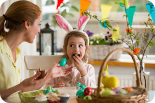 Ostern mit Kindern | Mutter und Tochter sitzen am gedeckten Ostertisch 