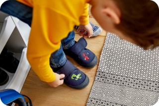 Was braucht man für Kindergarten und Kita | Kind zieht Hausschuhe an