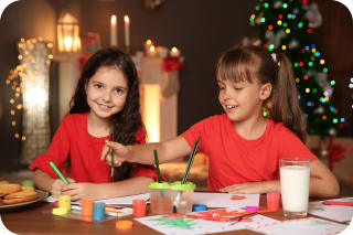 Weihnachtsdeko basteln | Zwei Mädchen malen mit Pinseln auf Papier
