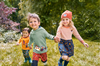 Über HABA | Spielende Kinder auf einer Wiese