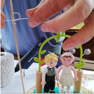 DIY-Anleitung: Hochzeitsgeschenk | Stab wird neben Brautpaar-Figur angebracht