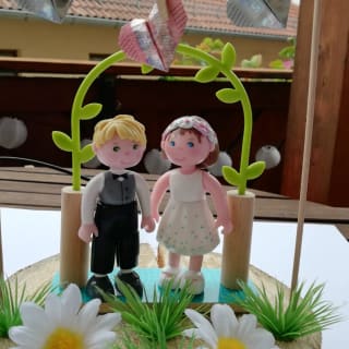 DIY-Anleitung: Hochzeitsgeschenk | Herzform gefaltete Geldscheine werden am Bogen über Brautpaar angebracht.