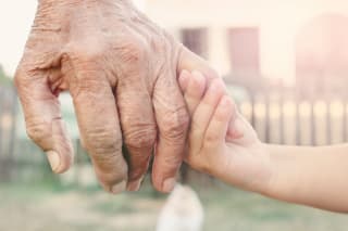 Kindern den Tod erklären | Kinderhand hält Hand eines älteren Menschen