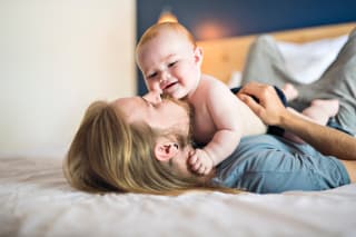 Familienzusammenhalt | Vater sitzt mit Kleinkind auf einem Steg 