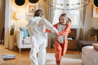 Faschingsspiele Kinder | 2 Mädchen tanzen verkleidet im Wohnzimmer