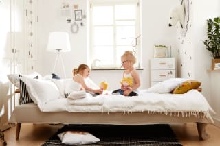Kinderzimmer teilen – wie lange | Zwei Kinder sitzen auf Bett und spielen