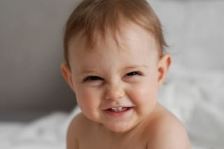 Baby zum Lachen bringen | Baby liegt bei Vater im Arm und lacht