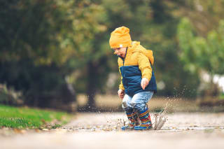 Unternehmungen mit Kleinkind | Kind springt in Pfütze