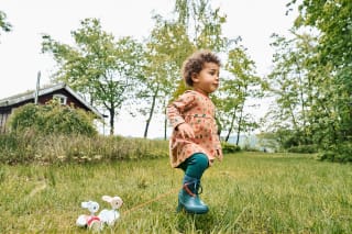Kinder fördern | Mädchen hüpft im Gras