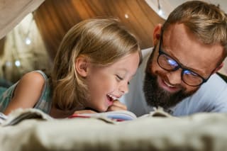 Geschichten erfinden | Papa und Tochter schauen in ein Buch