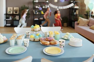 Kinderspiele selber machen | Dekorierter Tisch, im Hintergrund spielen Kinder