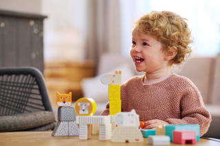 Baby Entwicklung Monat 16 | kleines Kind spielt mit Stapelbausteine