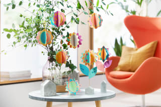  Blumen basteln mit Kindern | Papierblumen hängen an Ästen-Strauß in einer Vase und auf Holzständern.