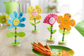 Blumen basteln mit Kindern | Bunte Blumen aus Filz, mit Steinchen und Wackelaugen stehen auf einem Tisch