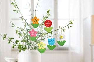 Blumen basteln mit Kindern | Gebastelte Papierblumen hängen an einem Strauß aus Ästen