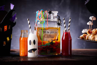 Halloween Rezepte | Grusel-Bowle mit Spinnen und Gummifäden, Geister-Milch-Glas, Orangen-Blut-Glas, Blut-rote-Schorlen-Drink stehen auf einem Tisch