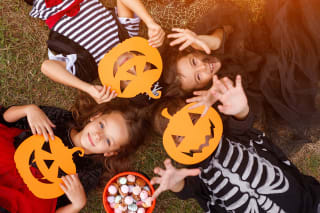 Halloween schminken |  Kinder liegen auf  dem Boden und haben Kürbismasken auf