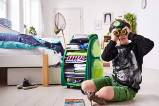 Kinderzimmer gestalten | Junge am Boden mit Fernglas und Trolley im Hintergrund