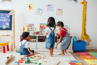 Alternative Kindergartenkonzepte | Kleinkinder spielen barfuß in einem Kitaraum