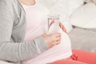 Schwangerschaft 11 SSW | Frau hält Glas Wasser