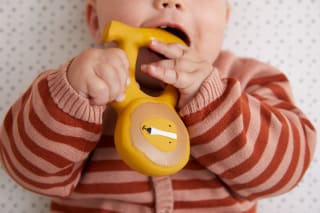 Warum spielen wichtig ist | Baby hält Beißring in Mund 