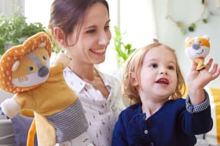 Spielerische Sprachförderung von Kindern | Mutter spielt mit Handpuppe Löwe zusammen mit Kind 