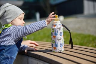 Trinken: wieviel und was für Kinder | Kind greift nach seiner Nuckelflasche