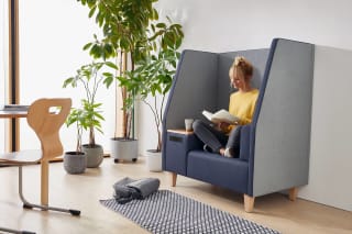 Freizeitraum | Grid | 2 | Polster | Frau mit gelben Shirt sitzt auf einem Sofa und liest ein Buch