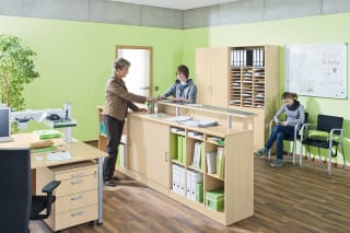 Schule & Hort |Verwaltungsräume | Frau steht hinter Tresen , Kind davor, ein Kind sitzt auf einem Stuhl