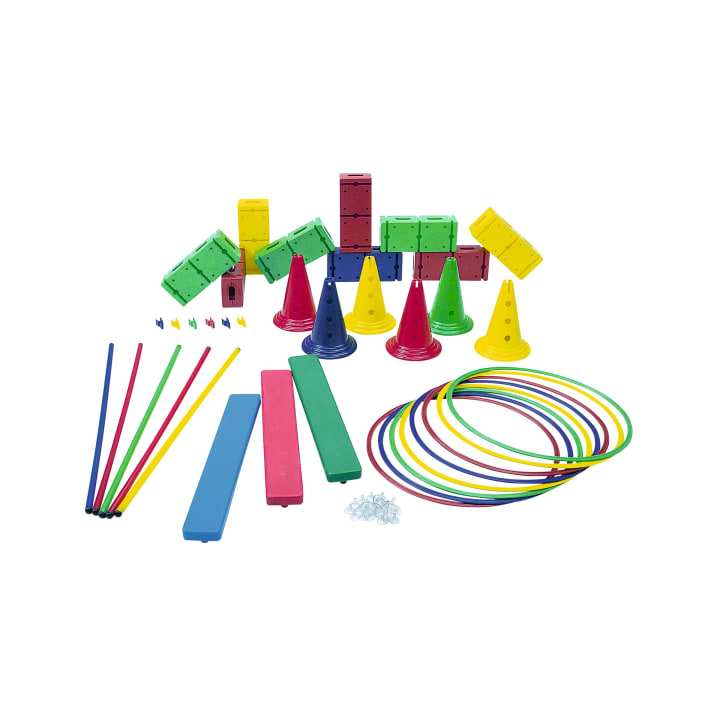 Verschiedene bunte Turngeräte wie Kegel, Reifen, Balancierbalken, Stangen, Blöcke und kleine Wäscheklammern auf einem weißen Hintergrund.