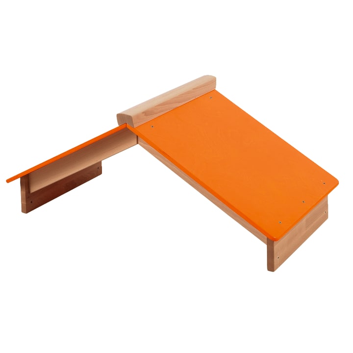 Eine Holzkonstruktion mit einer orangefarbenen schrägen Rampe und einer kleineren orangefarbenen flachen Plattform an der Seite. Die Konstruktion erscheint stabil und einfach, mit sichtbaren Schrauben zur Befestigung der Platten.