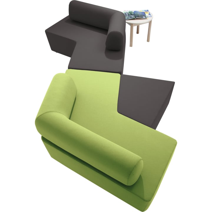 Zwei moderne, L-förmige Sofas - ein grünes und ein dunkelgraues - sind in einem Zickzack-Muster angeordnet. Ein kleiner, runder Beistelltisch aus Holz mit mehreren Zeitschriften steht daneben.