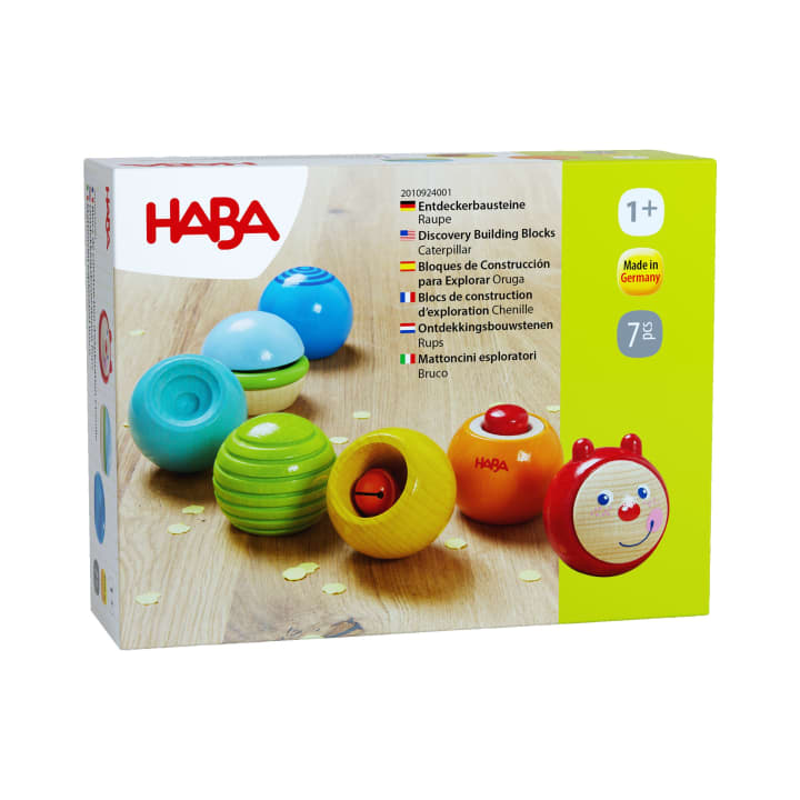 Eine Schachtel mit HABA-Entdecker-Bausteinen für Kinder ab 1 Jahr. Die Schachtel zeigt fünf bunte runde Bausteine und einen roten Käfer mit einem lächelnden Gesicht. Die Verpackung enthält Produktinformationen in mehreren Sprachen.