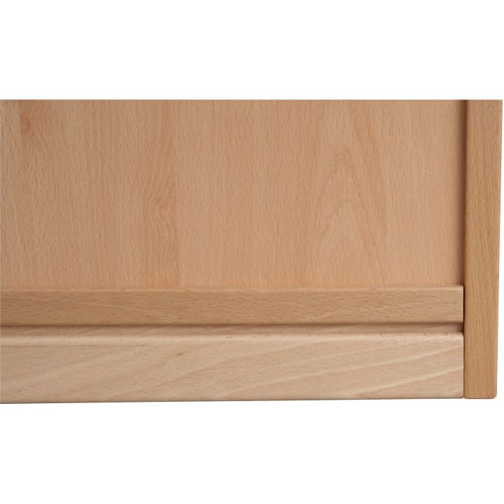 Nahaufnahme einer hellen Schranktür aus Holz mit einer horizontalen Zierleiste im unteren Bereich und einem vertikalen Rahmen auf der rechten Seite. Die Holzmaserung ist auf der gesamten Oberfläche sichtbar.