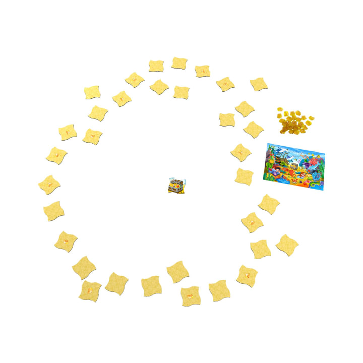Ein Brettspiel besteht aus einer zentralen Karte, einer kreisförmigen Anordnung von quadratischen Spielsteinen, einem Stapel kleiner Goldplättchen und einem bunt illustrierten Spielbrett auf weißem Hintergrund.