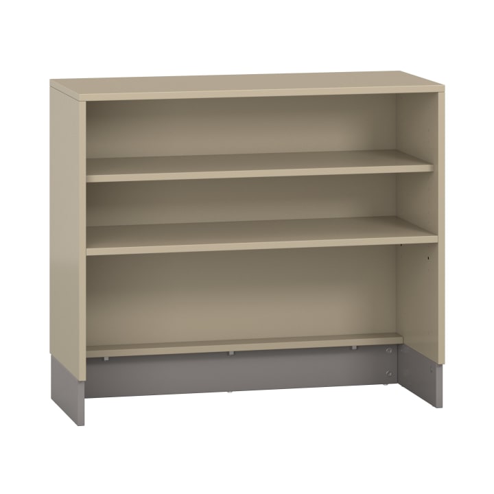 Ein beigefarbenes, offenes Bücherregal mit drei Fächern, massiver Rückwand und Metallsockel, abgebildet auf weißem Hintergrund. Die Regale sind leer und verstellbar.