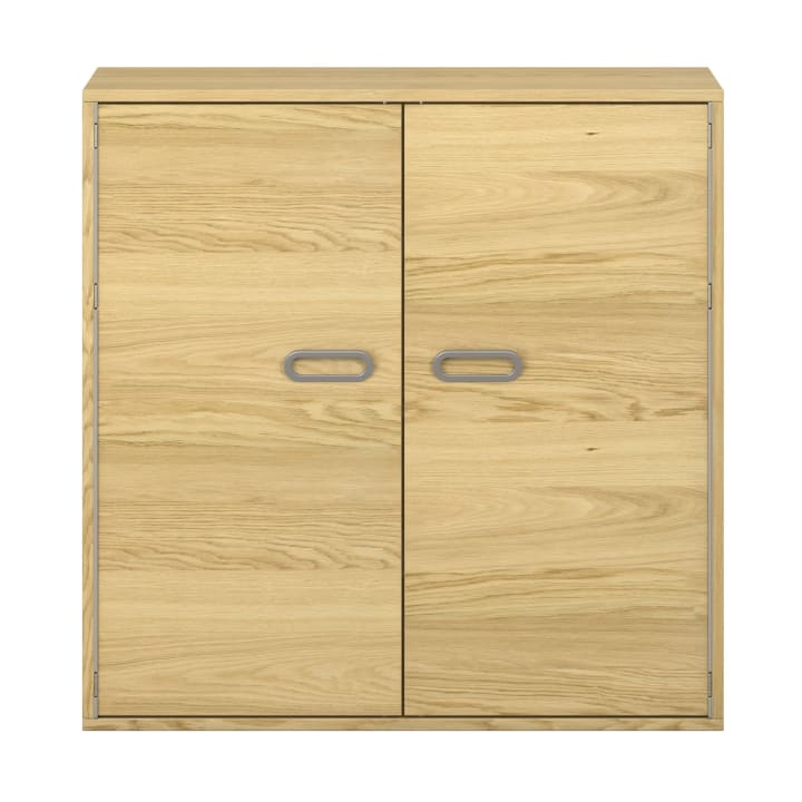 Ein heller Holzschrank mit zwei Türen, die jeweils einen ovalen grauen Griff in der Mitte aufweisen. Der Schrank hat ein einfaches, rechteckiges Design und ist mit einer natürlichen Holzmaserung versehen.