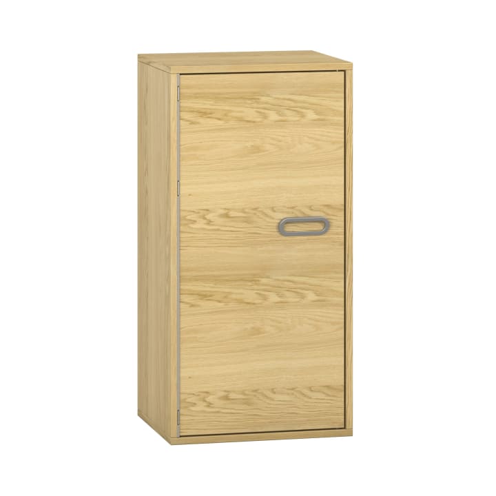 Ein rechteckiger Holzschrank mit einer einzigen Tür und einem grauen ovalen Griff, der sich durch seine helle Holzoberfläche und sein einfaches Design auszeichnet und vor einem schlichten weißen Hintergrund steht.
