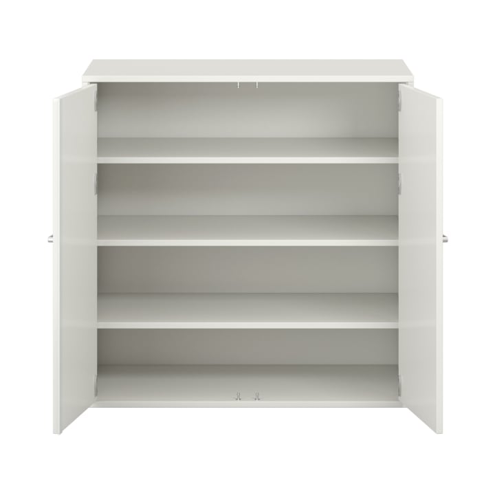Ein weißer Schrank mit zwei offenen Türen und vier leeren Einlegeböden, von vorne gesehen vor einem schlichten weißen Hintergrund.
