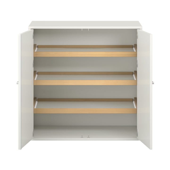 Ein weißer Schrank mit zwei offenen Türen gibt den Blick auf drei Einlegeböden frei, die jeweils mit einer hellen Holzleiste an der Vorderkante versehen sind. Der Schrank ist leer und wurde vor einem schlichten weißen Hintergrund fotografiert.