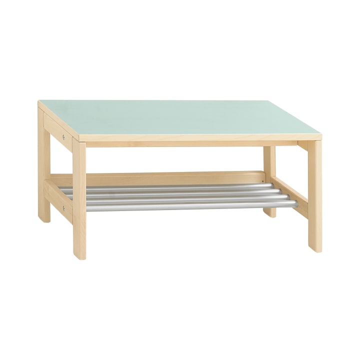 Rechteckiger Couchtisch aus Holz mit hellen Beinen, einer hellgrünen Tischplatte und einer unteren Ablage aus horizontalen silbernen Metallstäben. Der Tisch steht vor einem schlichten weißen Hintergrund.